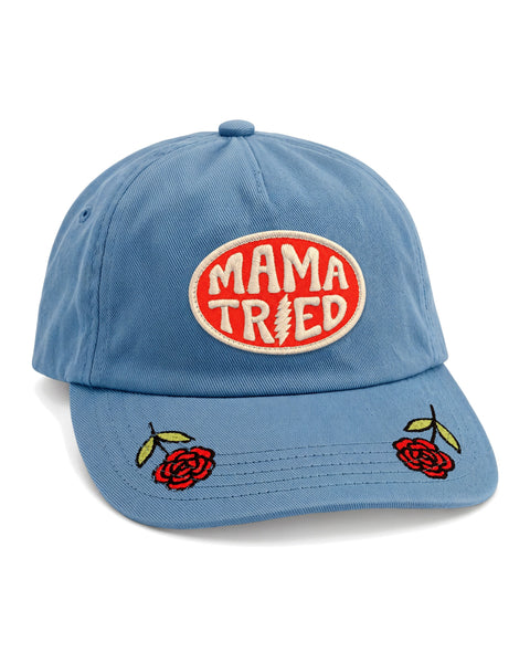 Mama Tried Hat in dusty blue with an orange oval patch reading Mama Tried and red roses embroidered on the brim, on white.