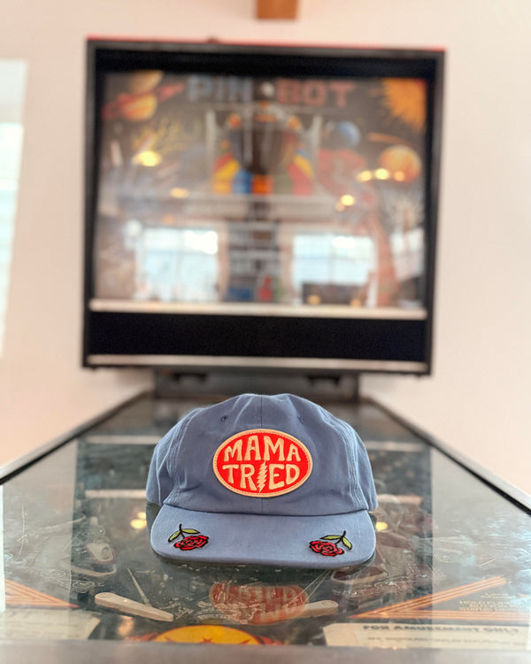 Mama Tried Hat displayed on a table with a vibrant background, showcasing its unique design and style.