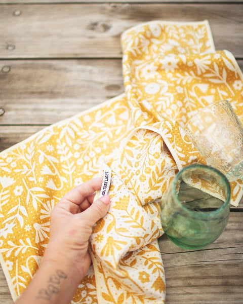 Meadow Kitchen & Tea Towel in vibrant yellow floral design, showcasing its absorbent and quick-dry features.