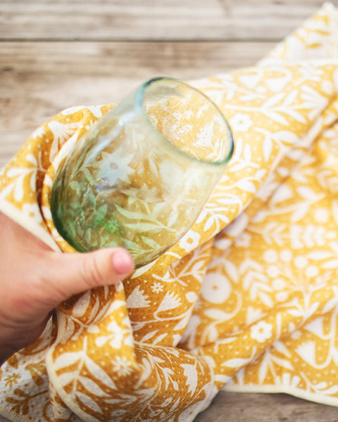 Meadow Kitchen & Tea Towel used to dry a glass, showcasing its vibrant design and absorbent material.