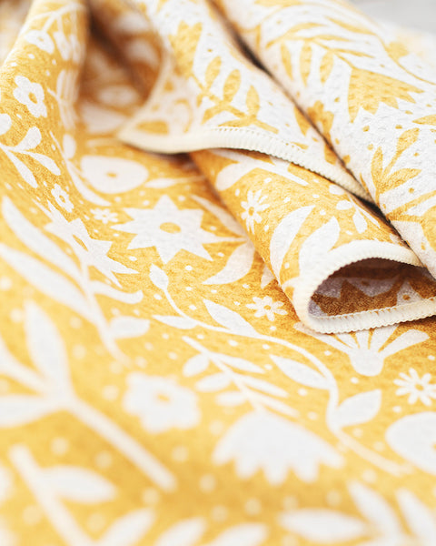 Close-up of the Meadow Kitchen & Tea Towel with floral design in yellow and white, showcasing texture and print.