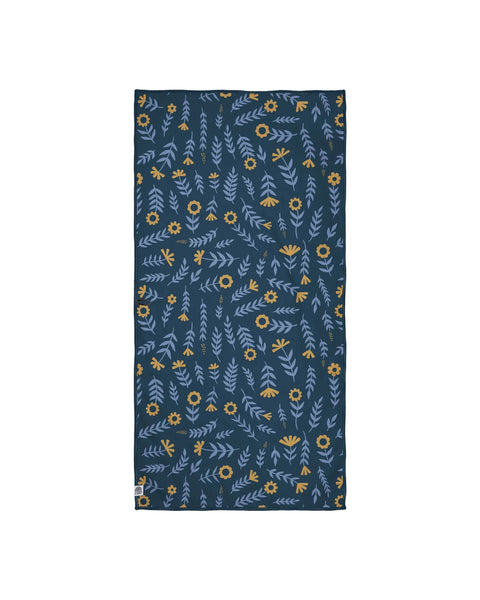 Mermaids Wander & Travel Towel featuring a floral and leaf pattern in blue and yellow on a dark background.