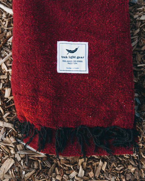 Cozy Trek Light Napa Blanket with rich red hue, made from recycled materials and handwoven for unique quality.