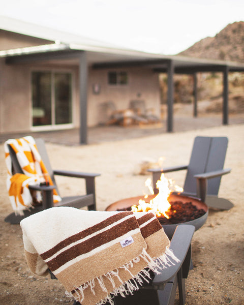 North Star Blanket draped over a chair beside a fire pit in an outdoor setting.