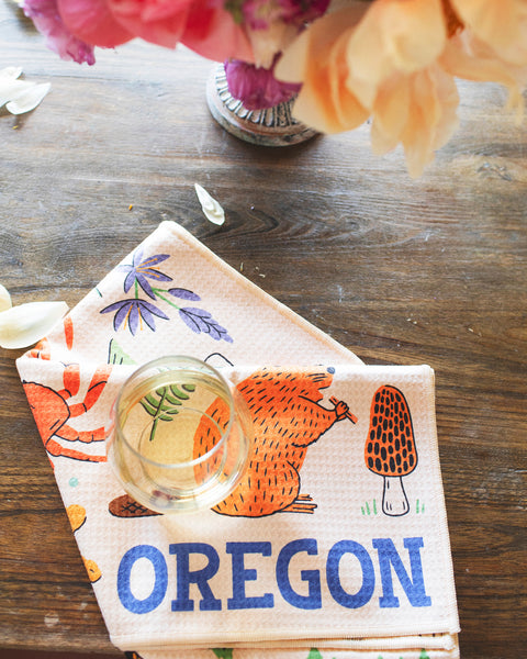 Oregon Kitchen & Tea Towel featuring designs of wildlife and plants, perfect for PNW pride and kitchen use.