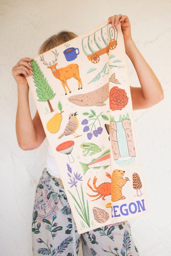 Oregon Kitchen & Tea Towel showcasing vibrant designs with nature illustrations, perfect for drying dishes.