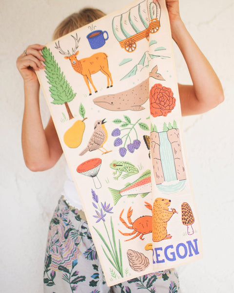Oregon Kitchen & Tea Towel showcasing vibrant designs with nature illustrations, perfect for drying dishes.