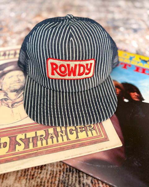 Rowdy Hat resting on vinyl records, showcasing its stylish design and comfortable flat brim.