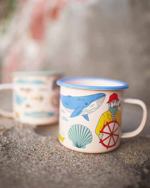 Salty Seas Enamel Mug 16oz with nautical design featuring a whale and sailor, perfect for campfires and cozy mornings.