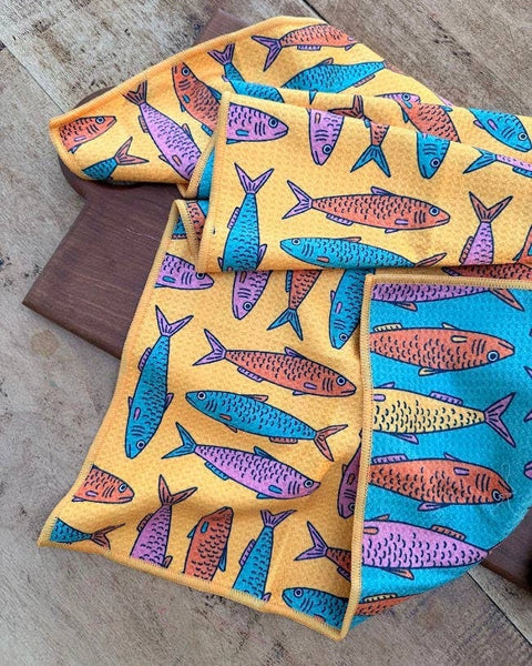 Sardine School Kitchen & Tea Towel featuring vibrant fish patterns on a colorful background.