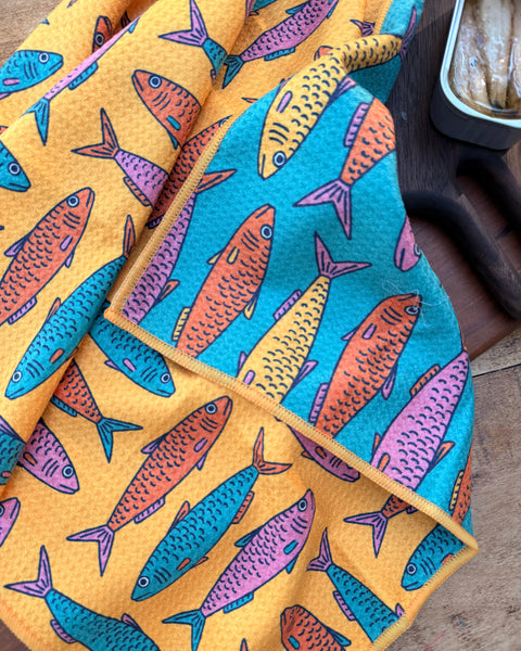 Sardine School Kitchen & Tea Towel featuring vibrant fish patterns on orange and blue fabric.