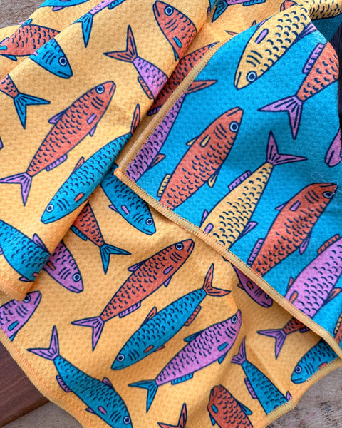 Sardine School Kitchen & Tea Towel featuring vibrant fish designs in blue, orange, and pink on a yellow background.