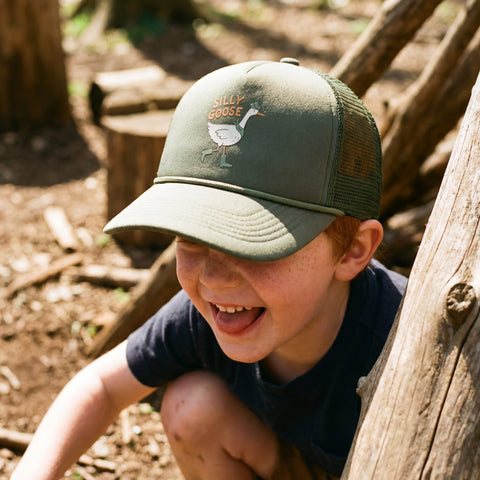 Child wearing a Silly Goose Kids Hat while playing outdoors, smiling and enjoying a sunny day.