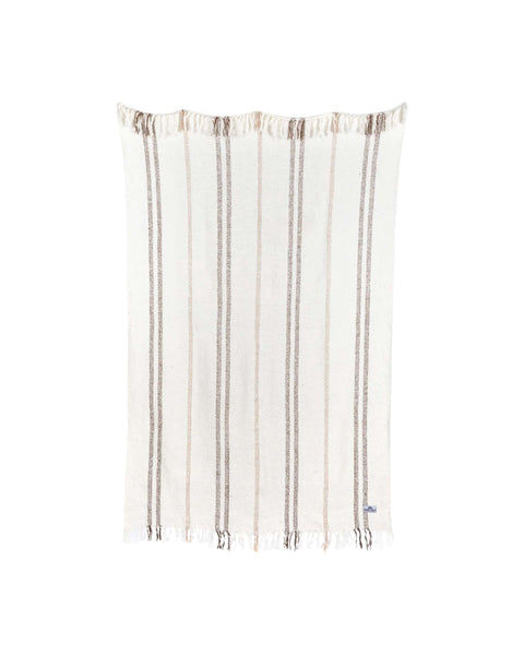 Silverton Blanket in cream with vertical brown and tan stripes and fringed ends, hung on white.
