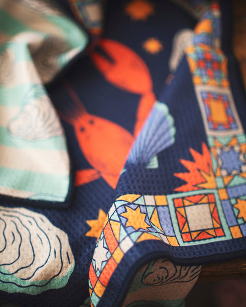 Snug Harbor Kitchen & Tea Towel featuring lobsters and nautical designs in vibrant colors, 18 x 30 inches.