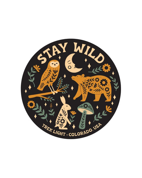Round Stay Wild Sticker in black with orange, cream and green folk art owl, bear, rabbit, mushroom and moon, on white.