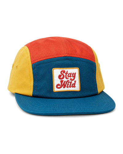 Stay Wild Kids Hat, a five-panel cap in orange, yellow and teal cotton twill with a white "Stay Wild" patch, on white.