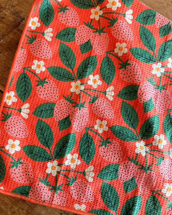 Strawberry Letter Kitchen & Tea Towel featuring vibrant strawberry and flower patterns on a coral background.