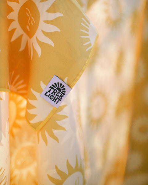 Sunny Wander & Travel Towel featuring a sunny design and TREK LIGHT tag. Perfect for travel and outdoor use.