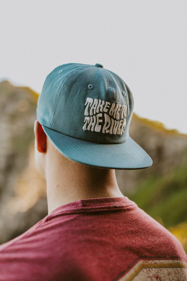 Trek Light Take Me To The River Hat on a person, perfect for outdoor adventures by the river. Stylish 6-panel snapback design.