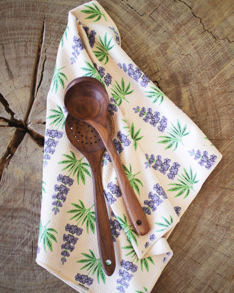 Texas Kitchen & Tea Towel with wooden utensils on a rustic wood surface, featuring vibrant floral design.
