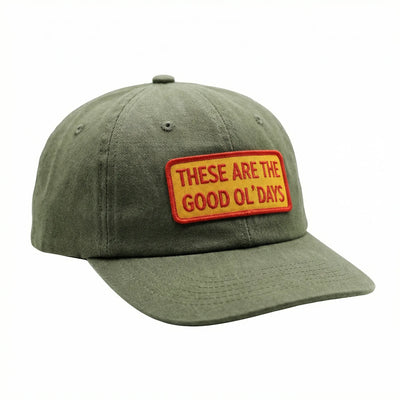 Olive green cap with 'These Are The Good Ol' Days' patch, adjustable fit, ideal for comfort and style, promoting positive vibes.