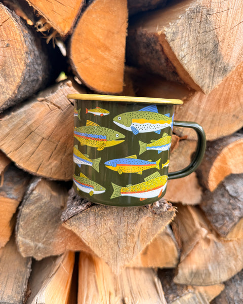 Trout Mug - Enamel 16oz Mug featuring colorful trout design against a backdrop of stacked logs.