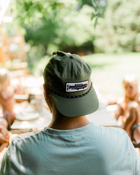 Person wearing a Trout Hat (Olive) while enjoying time outdoors with friends.