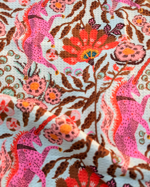 Colorful fabric featuring unicorns and flowers on Unicorn Dreams Kitchen & Tea Towel.