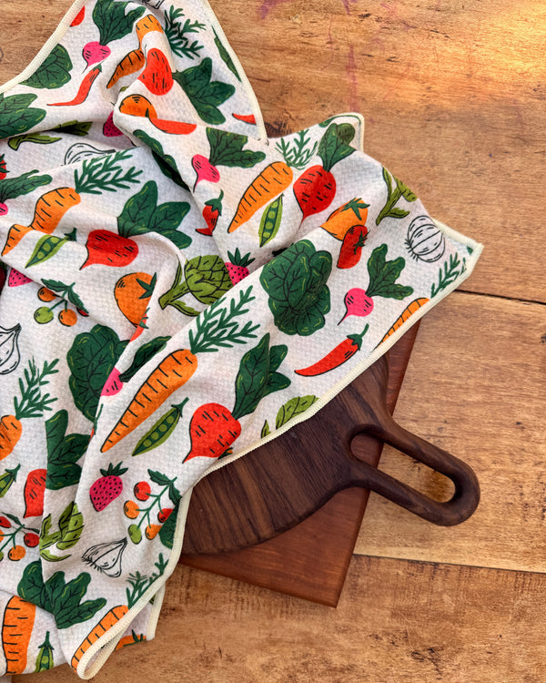 Veggie Medley Kitchen & Tea Towel featuring vibrant vegetable designs on a wood surface.