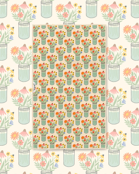 Wildflower mason jar pattern kitchen towel styled over a matching floral illustrated backdrop