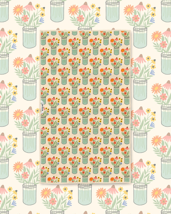 Wildflower mason jar pattern kitchen towel styled over a matching floral illustrated backdrop