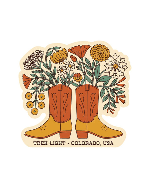 Western Bloom Sticker with orange and yellow cowboy boots holding colorful wildflowers, on white with a cream border.