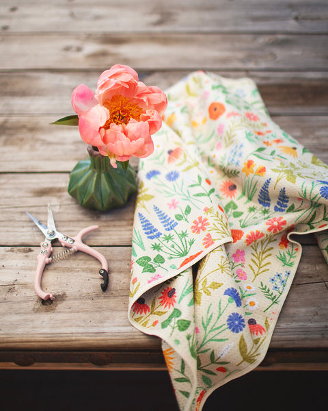 Wildflower Wonder Kitchen & Tea Towel displayed with a pink flower and garden shears on wooden table.