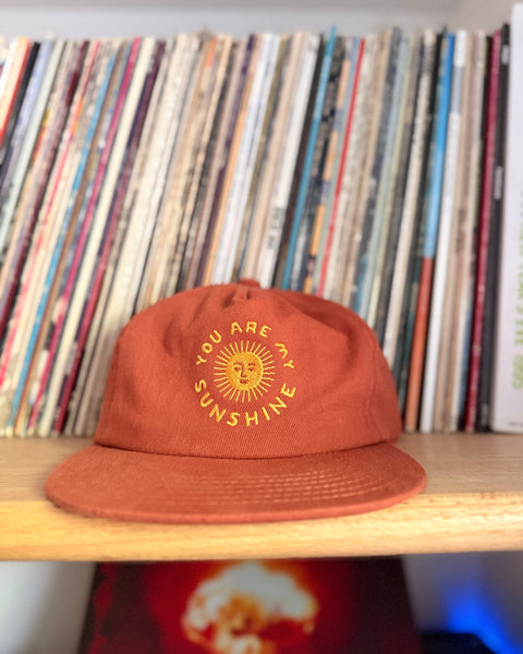 You Are My Sunshine Hat displayed on a shelf with vinyl records, featuring a 5-panel design.