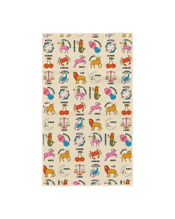 Zodiac tea towel design on cream background featuring zodiac symbols and animals scattered in an allover pattern with detailed illustrations of each astrological sign in rich jewel tones and pastels