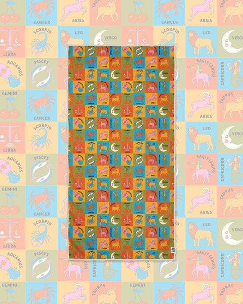Zodiac Wander & Travel Towel with a grid of colorful animal and sign illustrations on a faded matching background