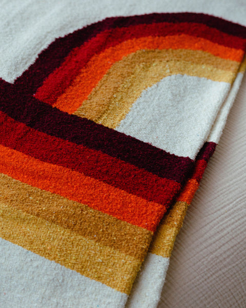 Colorful Trek Light Bowie Blanket with vintage rainbow design, made from recycled materials, folded on a soft surface.