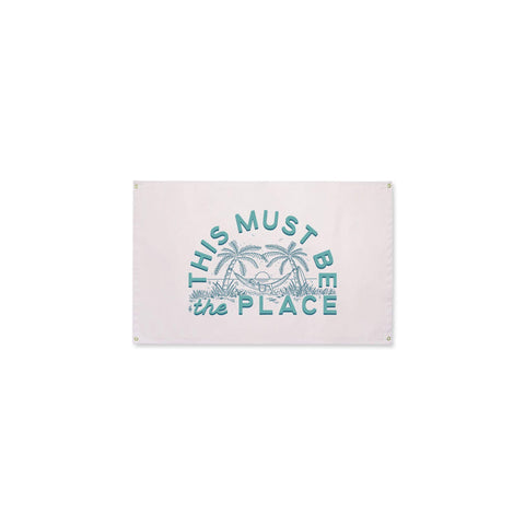 This Must Be The Place Canvas Flag with blue print on natural cotton by Trek Light, featuring 4 brass grommets for easy hanging.