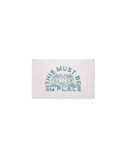 This Must Be The Place Canvas Flag in pale pink with teal palm tree and hammock print, with grommets, on white