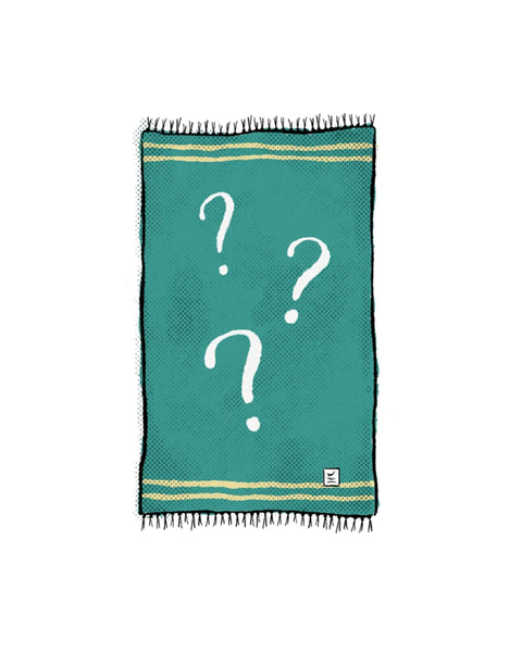 Mystery Blanket in teal with cream stripes at both ends, fringed edges and three white question marks, on white.