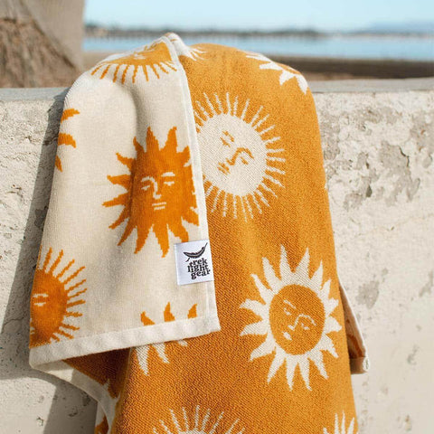 Sunny Bath Towel by Trek Light, featuring sun designs, made from 100% sustainable cotton for a soft, cozy, and absorbent experience.