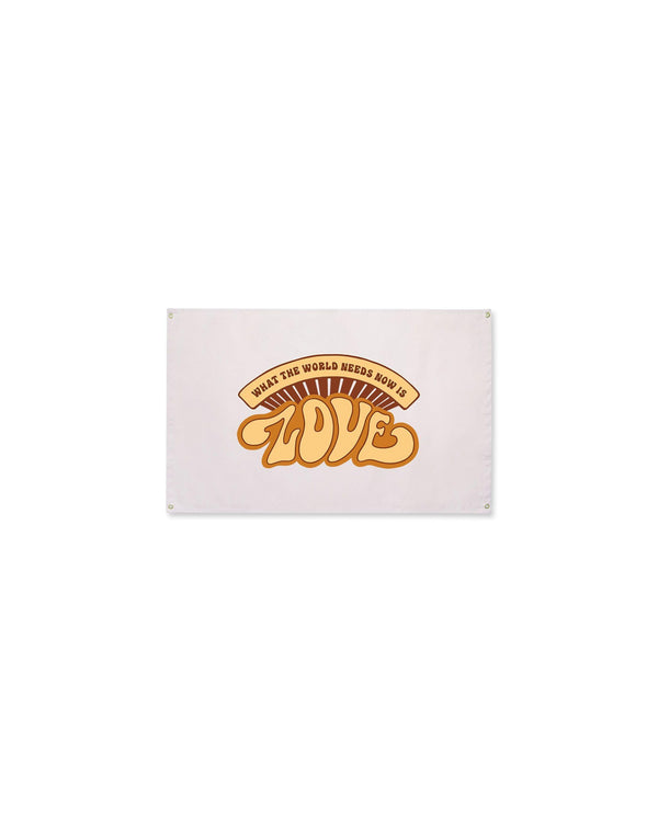 What The World Needs Now Canvas Flag in cream with a retro orange and brown "Love" graphic and grommets, on white.