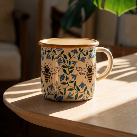 Honey Bee enamel mug 16oz with a vintage camp style design on a sunlit table