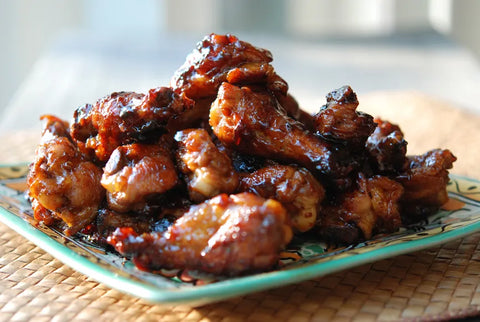 Close-up of glazed chicken wings on a decorative plate, featured in The Weekly Light Vol. 13.