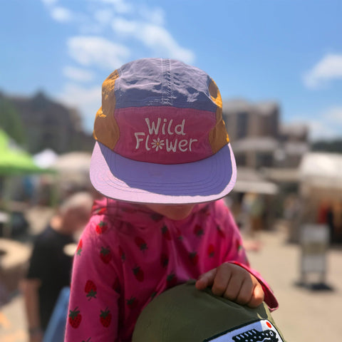 Child wearing a colorful Trek Light kids hat outdoors