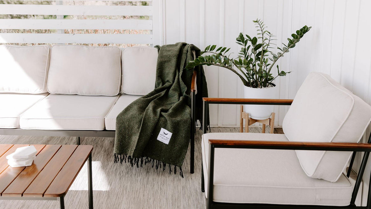 Cozy outdoor patio with a Trek Light solid color blanket draped over a sofa, enhancing relaxation vibes.