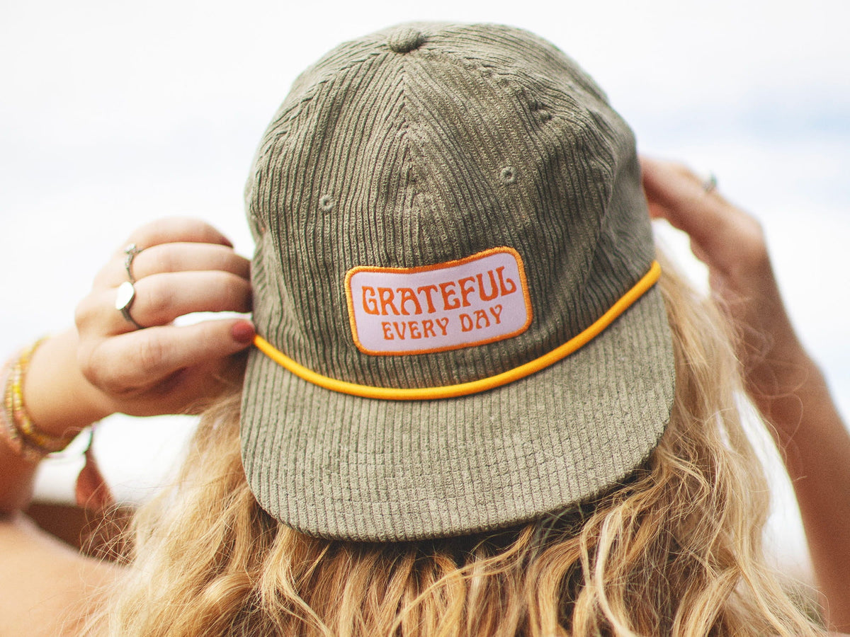Stylish "This Must Be the Place" hat on a surfboard, perfect for Trek Light adventures.