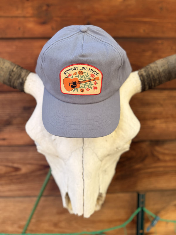 Support Live Music Hat displayed on a cow skull, featuring vibrant design and adjustable fit for everyday wear.