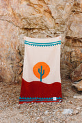 Cozy, versatile Arizona Blanket: handwoven from recycled clothing, featuring a cactus design in a beautiful desert sunset palette by Trek Light.